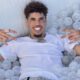 lamelo ball laying on ball pit smiling