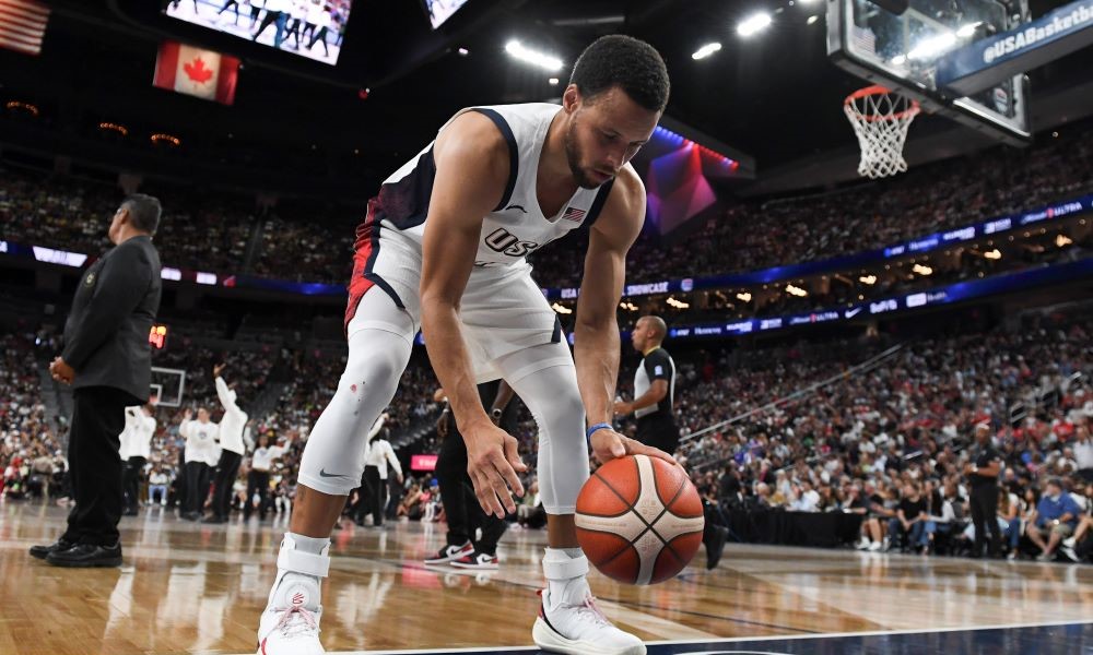 Steph Curry dribbling a basketball in Paris for Olympics.