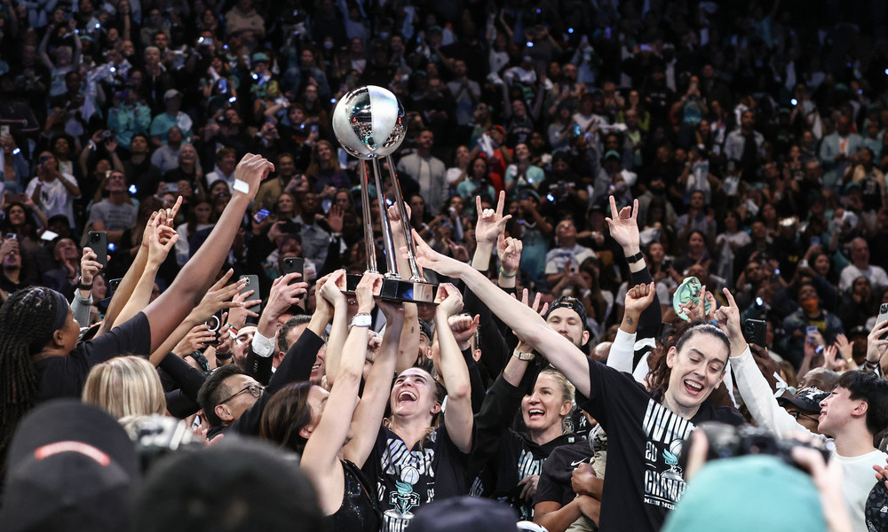 The New York Liberty holding up the trophy as they celebrate their finals win