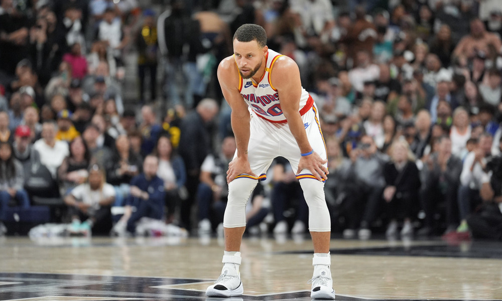 Stephen Curry with his hands on his knees while he catches his breath