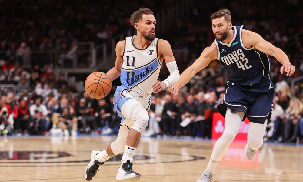 Trae Young attempting to drive past his defender, Maxi Kleber.