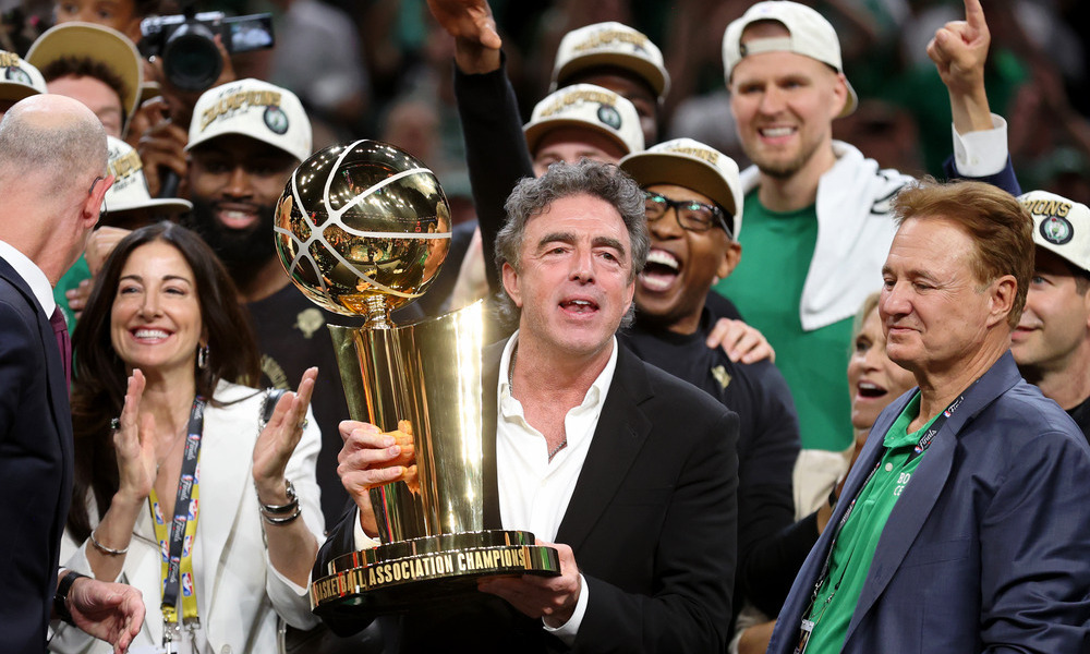 Wyc Grousbeck holding up the Larry O'Brien Trophy after winning the 2024 NBA Finals.