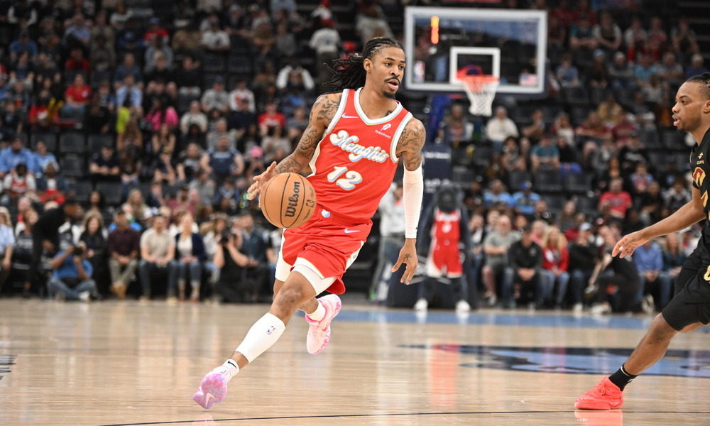 Ja Morant scans the floor as he drives towards the basket.