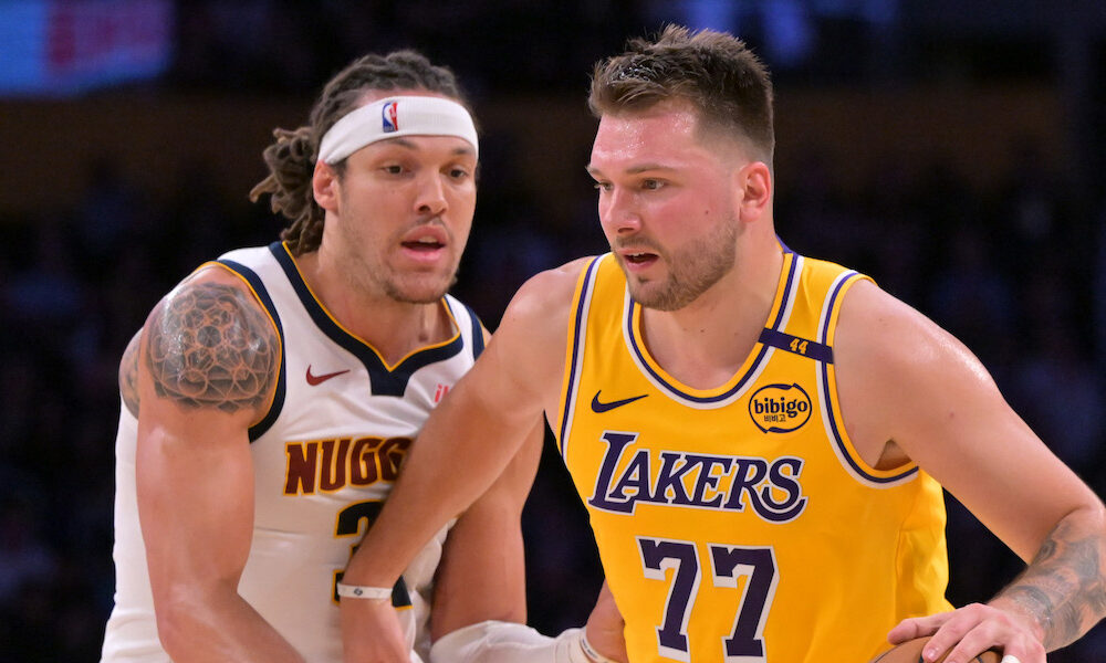 Lakers' guard Luka Doncic moving the ball past Nuggets forward Aaron Gordon in 2025 mattchup.