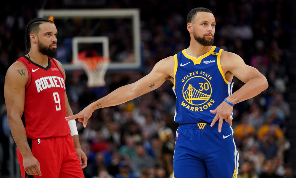 Stephen Curry and Dillon Brooks stand next to each other before play resumes.
