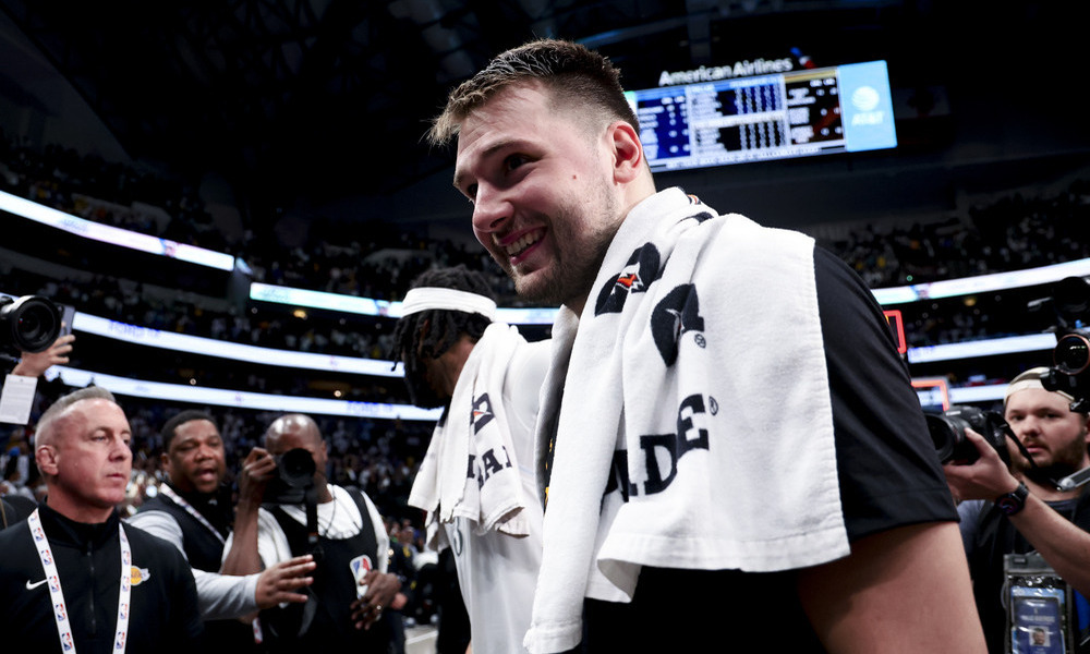 Luka Doncic smiling as he walks off the court.