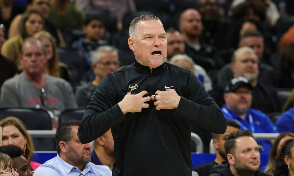 Mike Malone speaking to a referee during a game.
