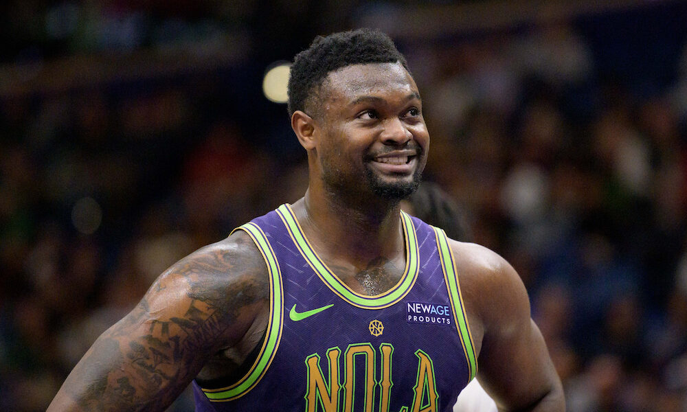 Zion Williamson smiles on court in matchup between Pelicans and Pistons.
