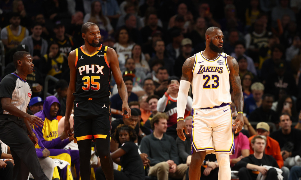 Kevin Durant and LeBron James stand on the court as they wait for play to resume.