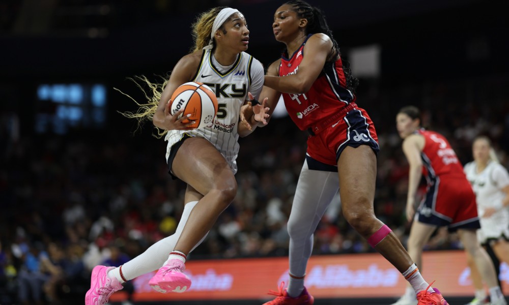 Angel Reese dribbling against defender