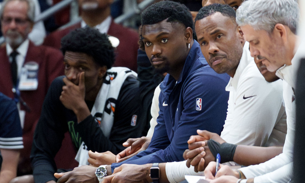New Orleans Pelicans forward Zion Williamson watching a game from the sideline.