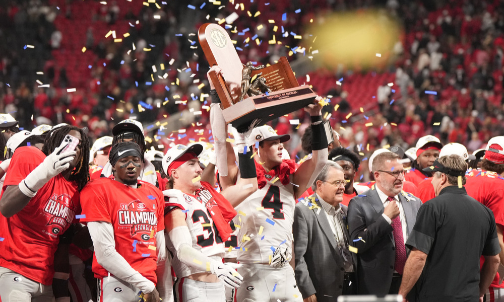 Georgia Bulldogs quarterback Gunner Stockton hoists the SEC championship trophy into the air.